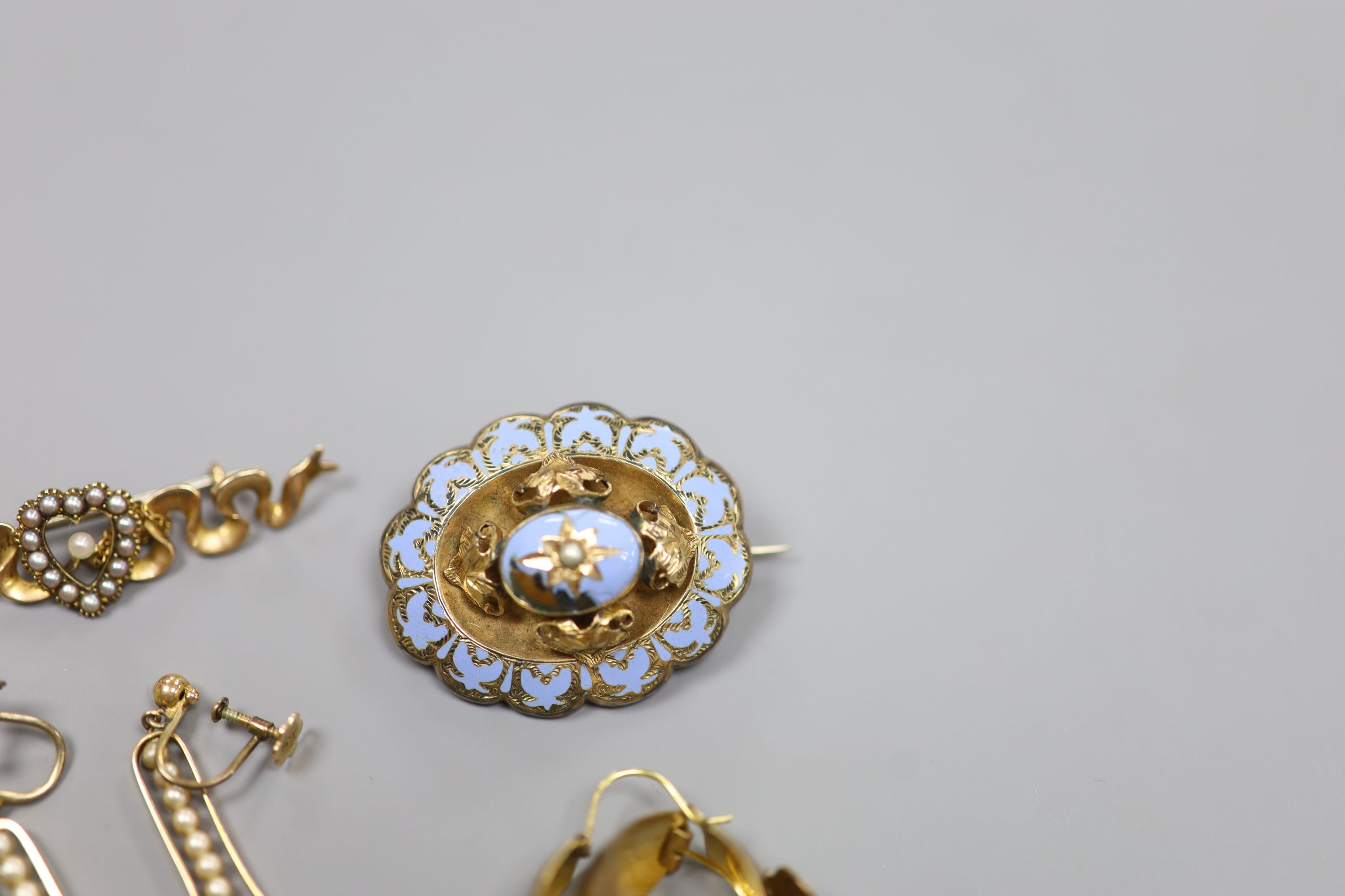 An Edwardian 15ct and seed pearl set bar brooch, 47mm, gross 4 grams, two pairs of 9ct earrings, gross 5,2 grams and a Victorian yellow metal and enamel (a.f.) mourning brooch.